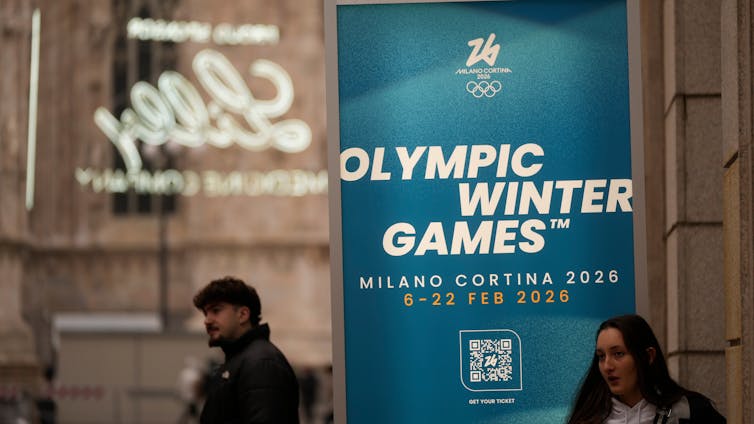 La geopolítica proyectará una larga sombra sobre los Juegos Olímpicos de Invierno de Milán Cortina en 2026. 2 La gente pasa junto a un cartel que dice