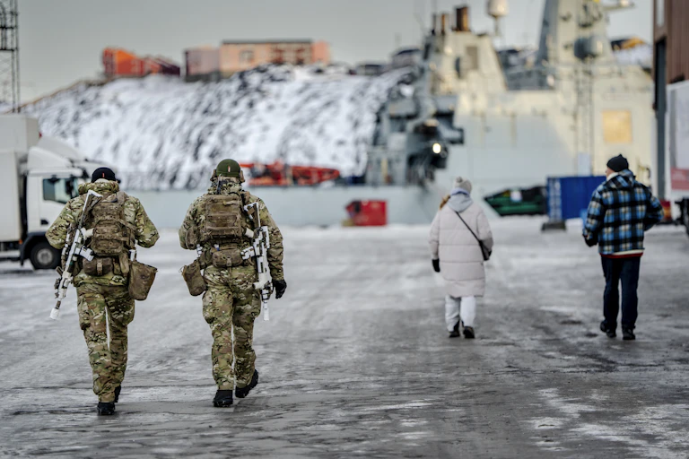 Danish soldiers walk next to a harbour in Greenland.