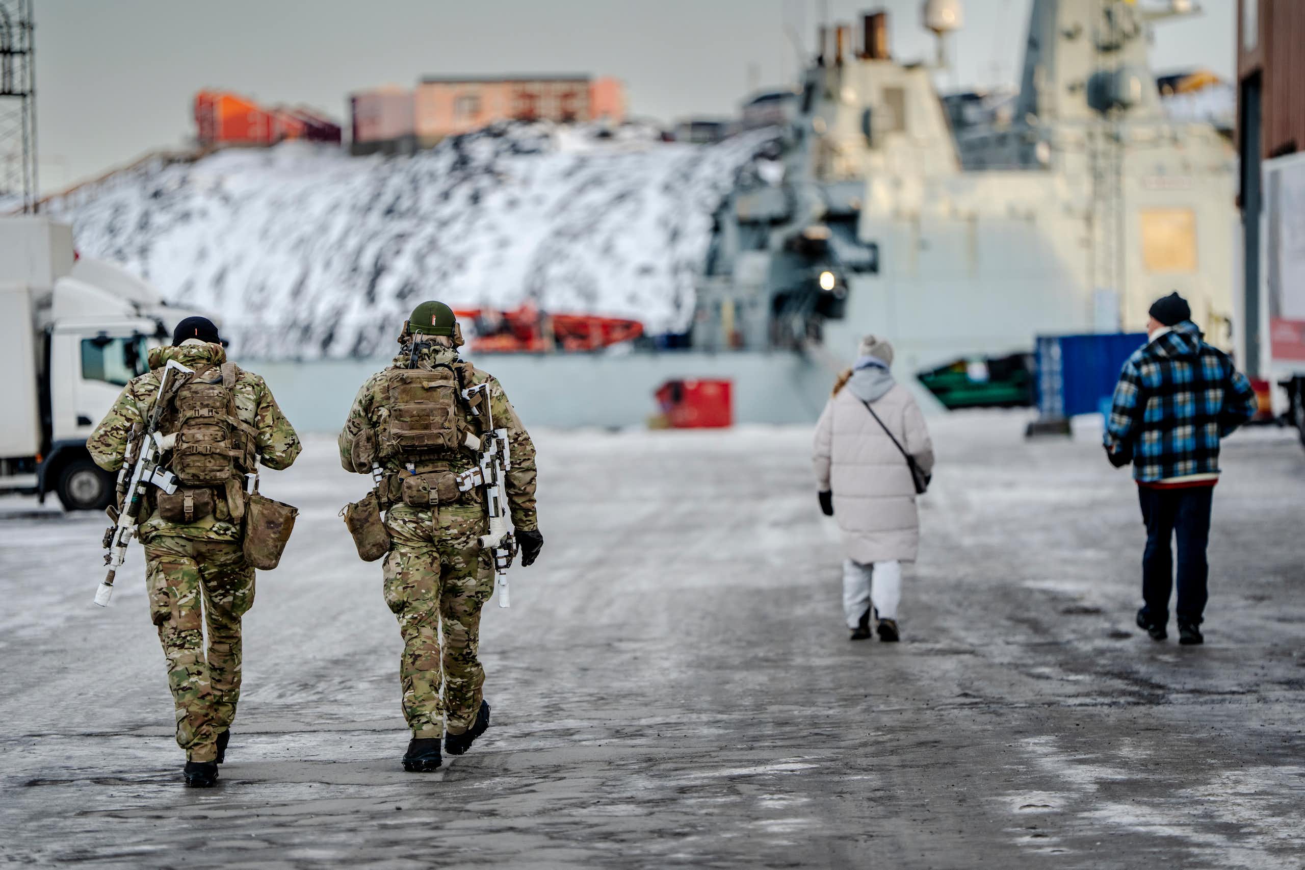 Danish soldiers walk next to a harbour in Greenland.