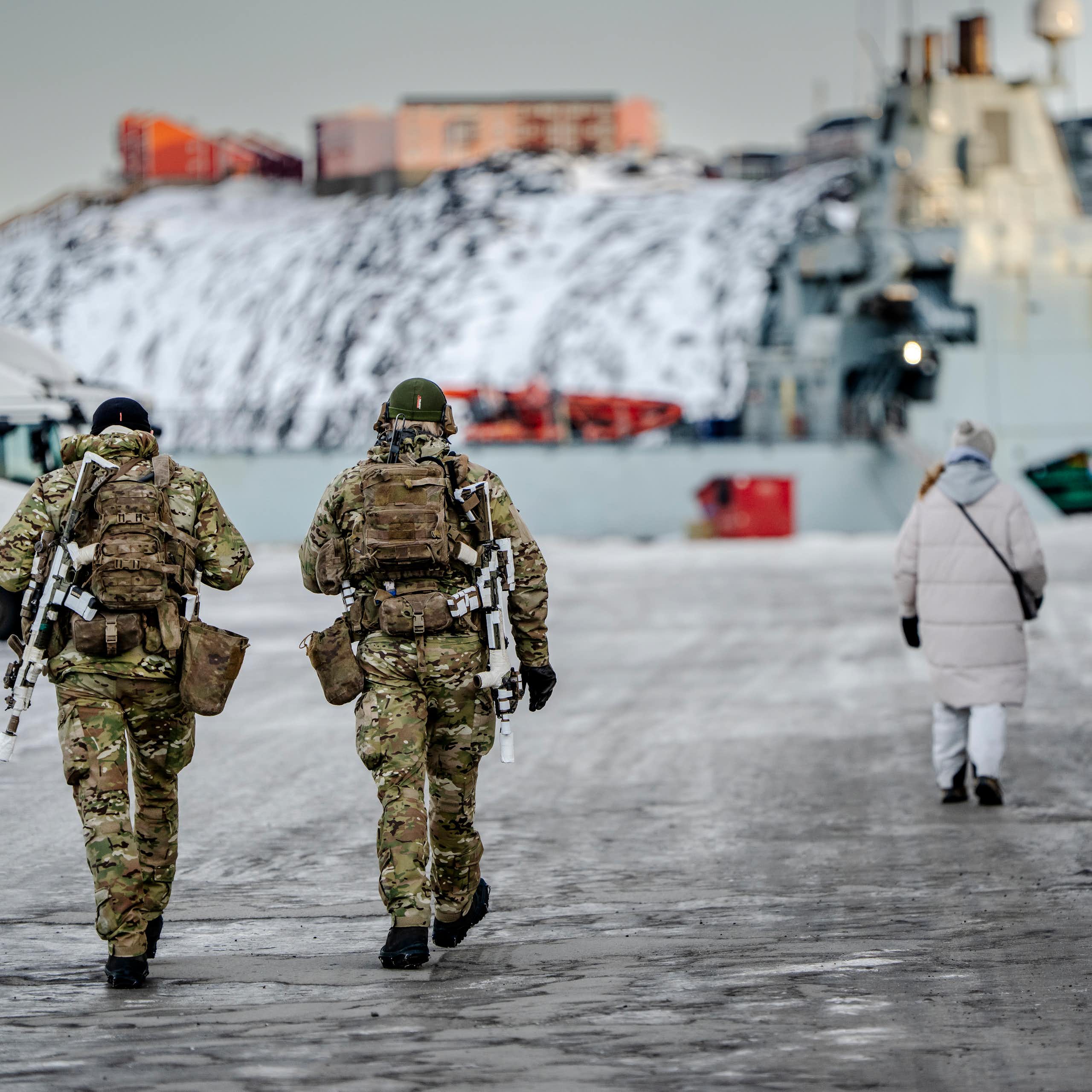 Danish soldiers walk next to a harbour in Greenland.
