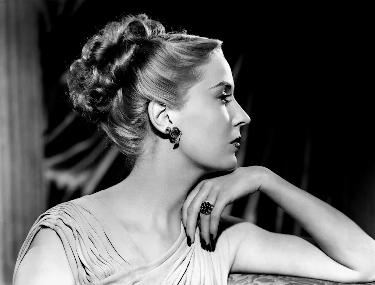 An elegant woman in Greek-style dress and hair.
