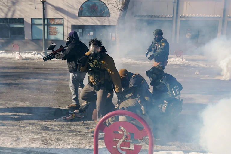Federal immigration agents (ICE) with firearms and tear-gas guns in Minneapolis, January 2026.