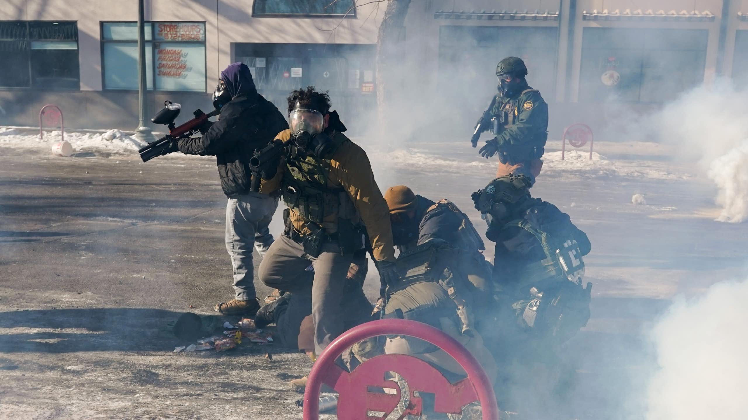 Federal immigration agents (ICE) with firearms and tear-gas guns in Minneapolis, January 2026.
