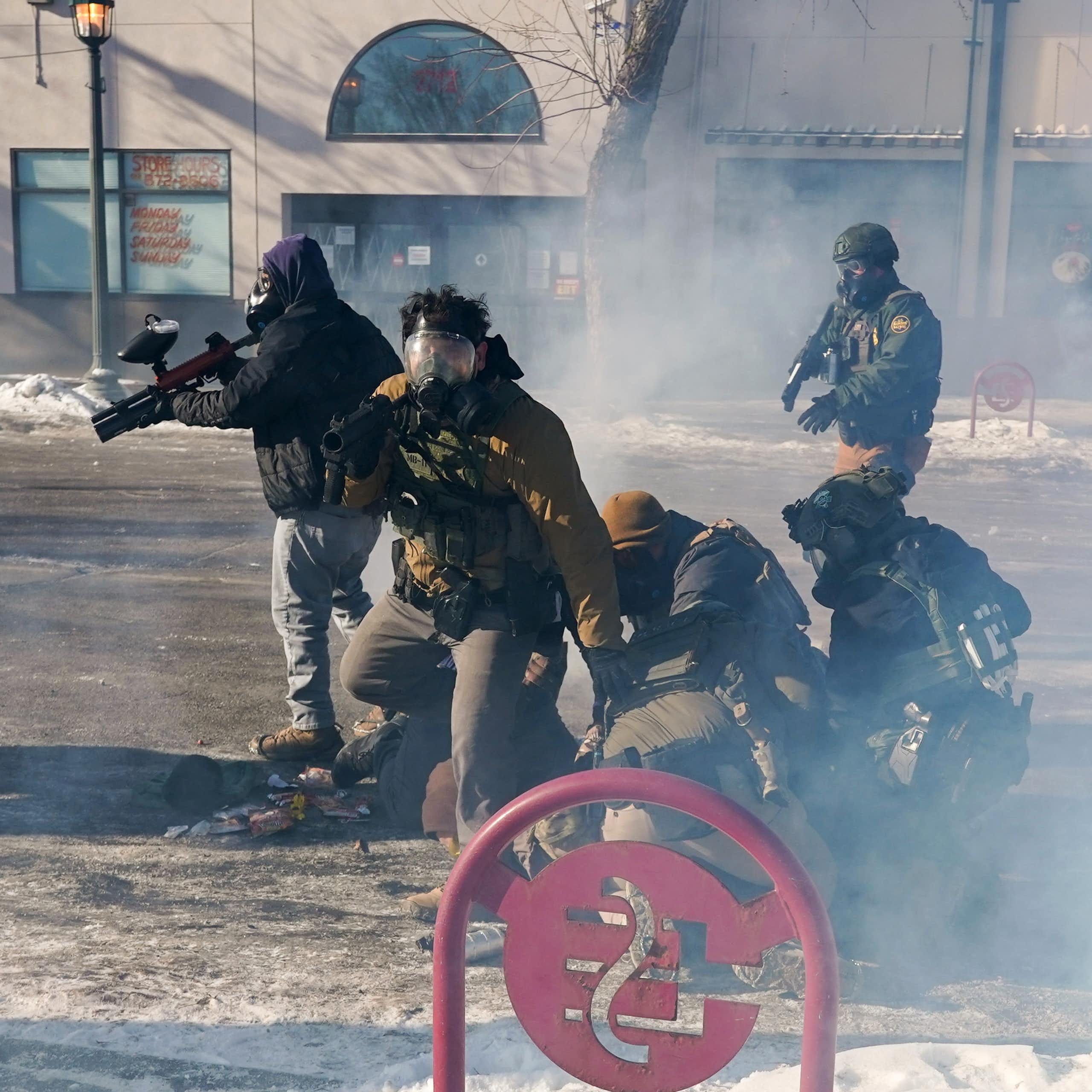 Federal immigration agents (ICE) with firearms and tear-gas guns in Minneapolis, January 2026.