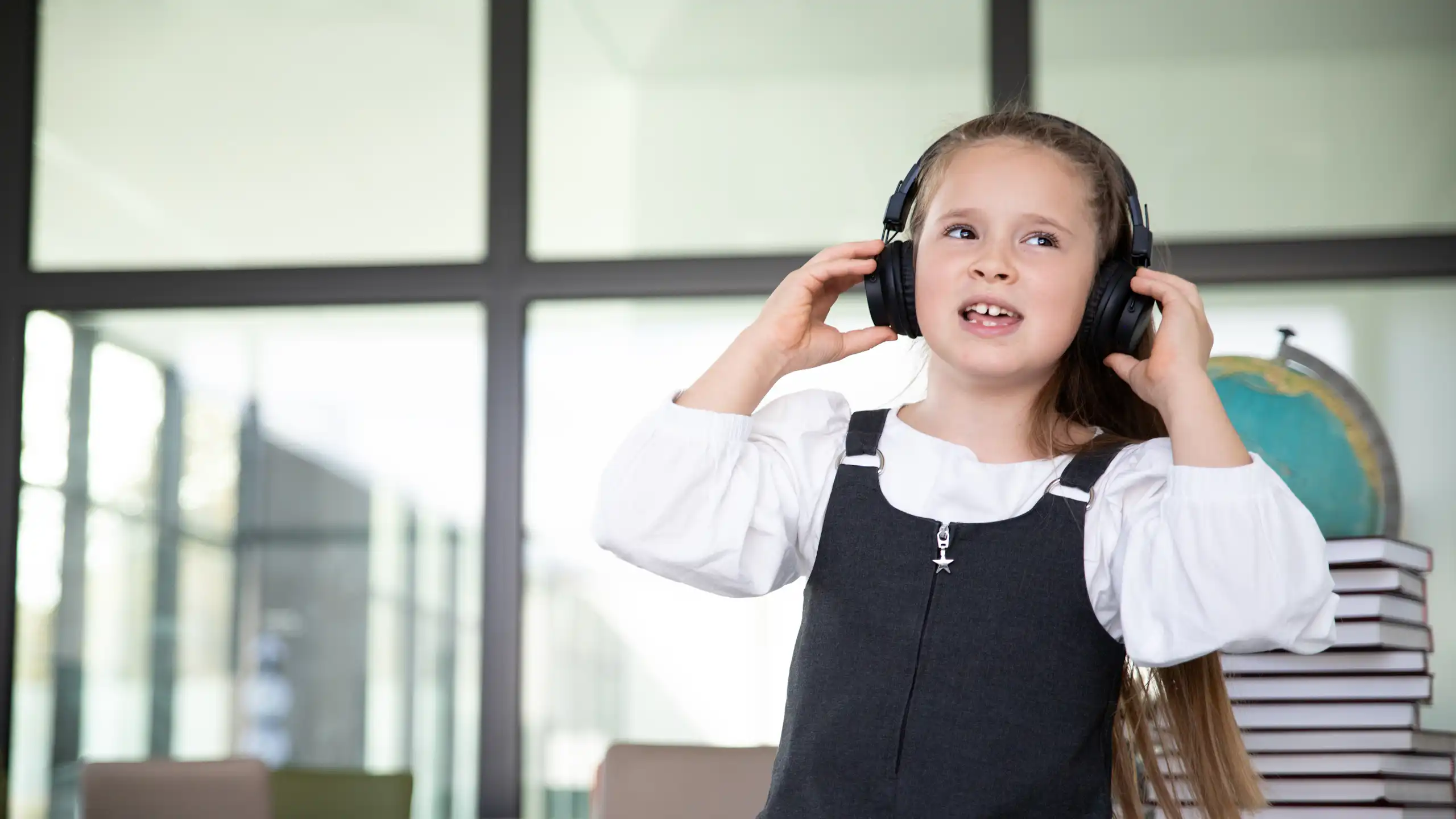 Little girl in school wearing headphones