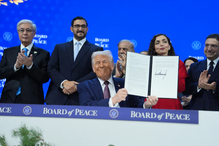 President Trump holds up a document he's signed regarding the formation of an international Board of Peace.