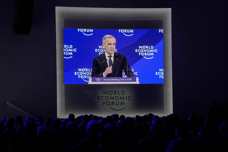 A video screen shows Canadian Prime Minister Mark Carney as he addresses the audience at Davos.