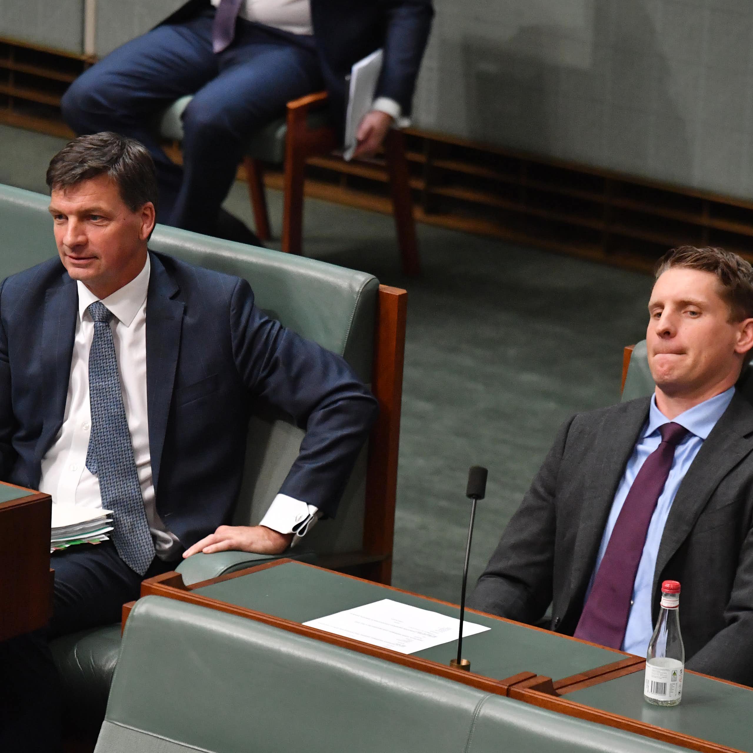 Two men in suits sit in the house of representatives