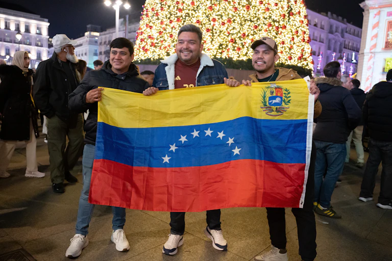 Tres hombres con una bandera venezolana.