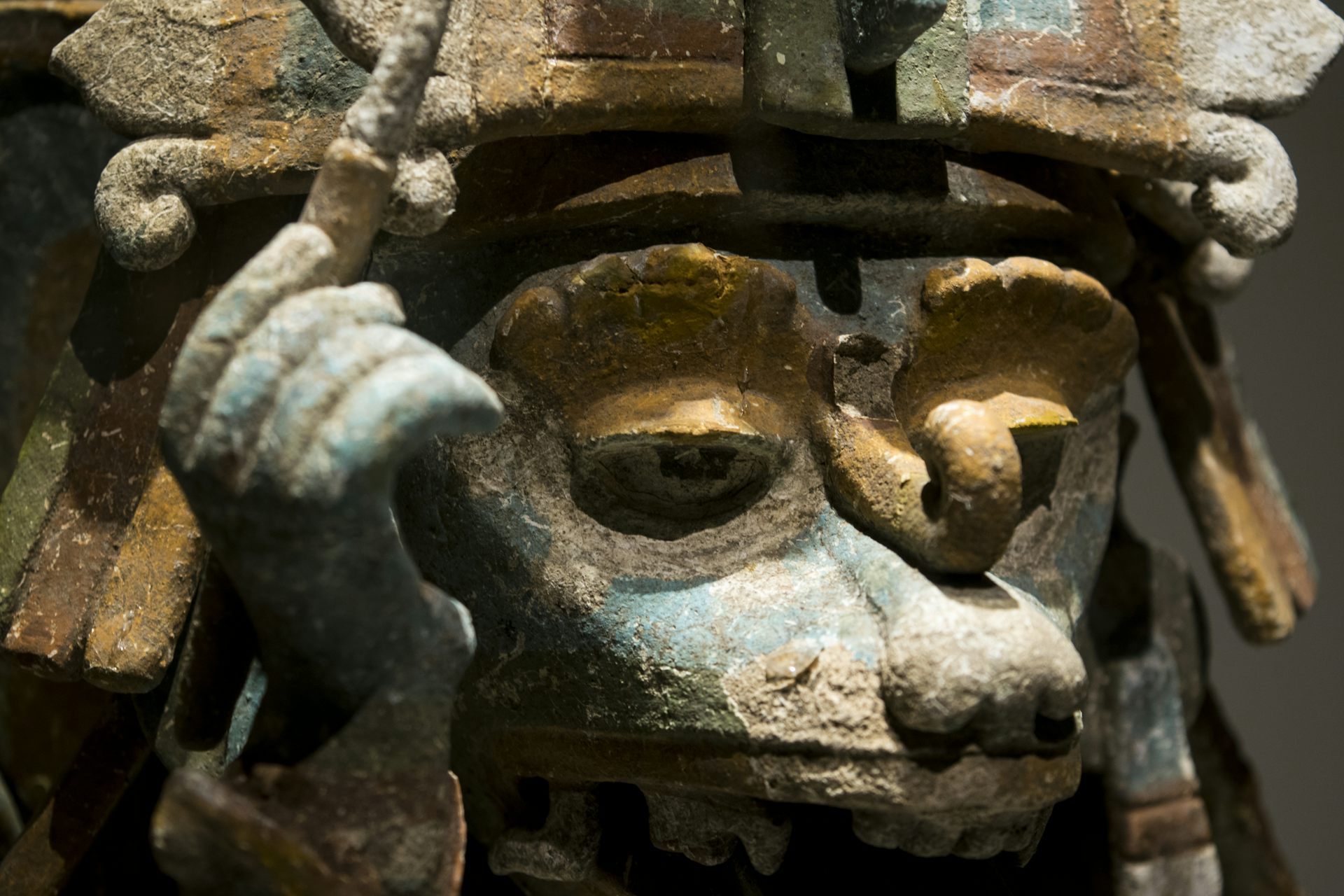 Escultura de un animal con un tocado y sosteniendo un últil de escritura.