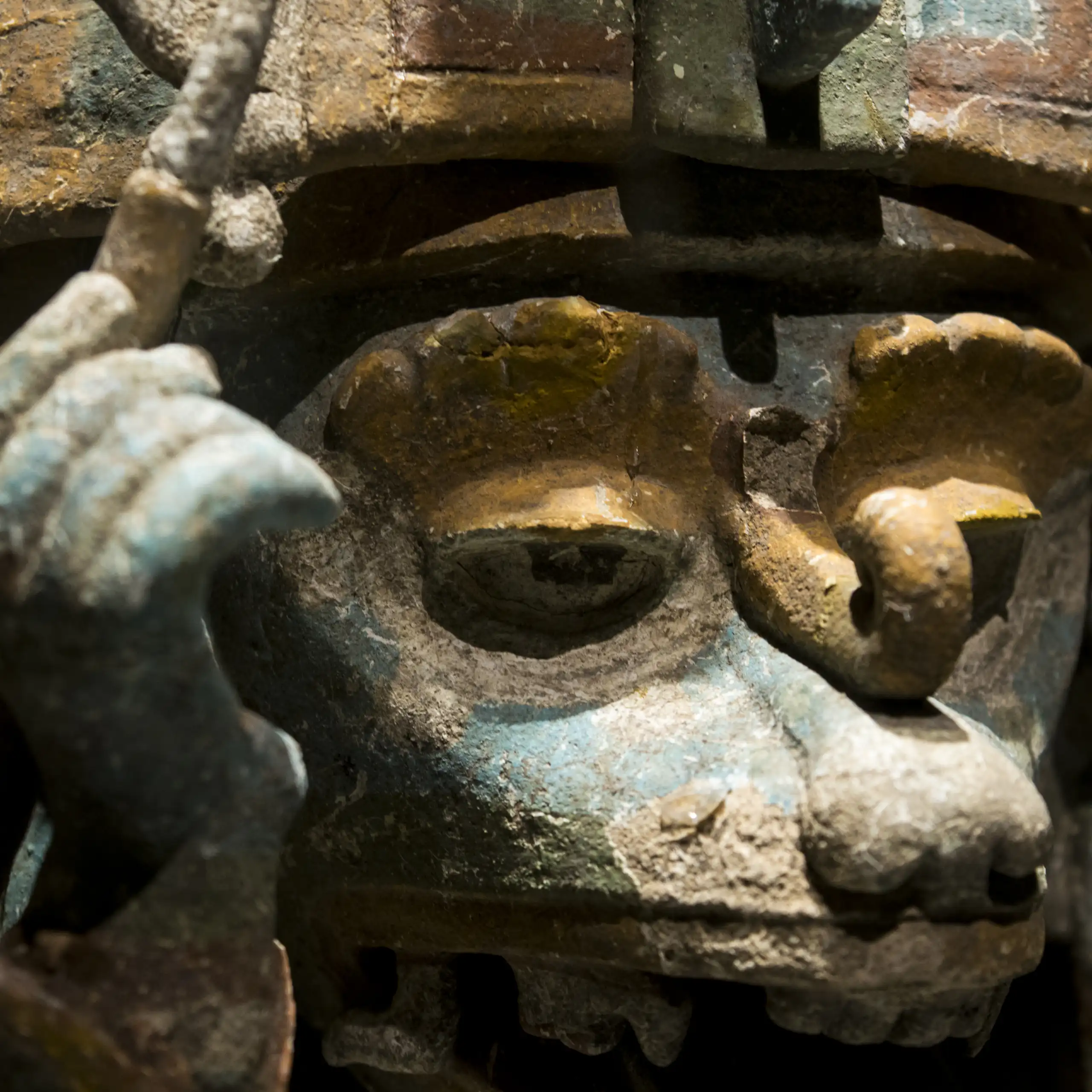 Escultura de un animal con un tocado y sosteniendo un últil de escritura.