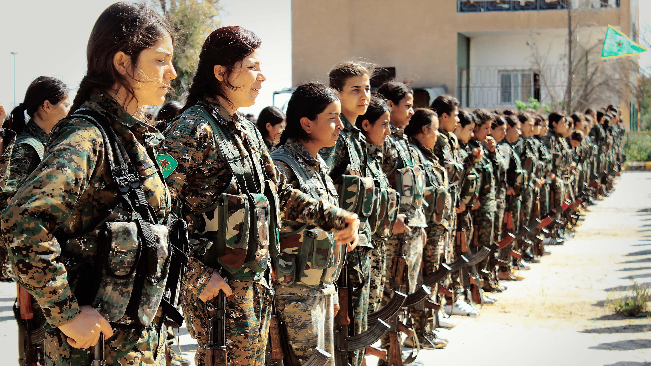 Kurdish fighters of the all-female Women Protection Units (YPJ) stand in formation.