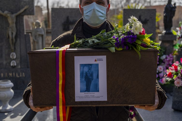 A man carries a box containing the remains of his uncle who was killed during Spain's fascist era.