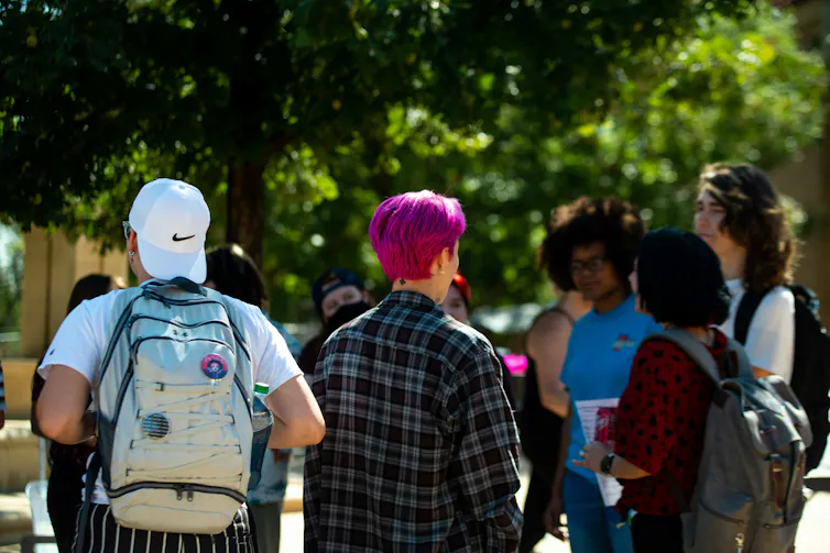 Young people in a crowd walking outdoors.