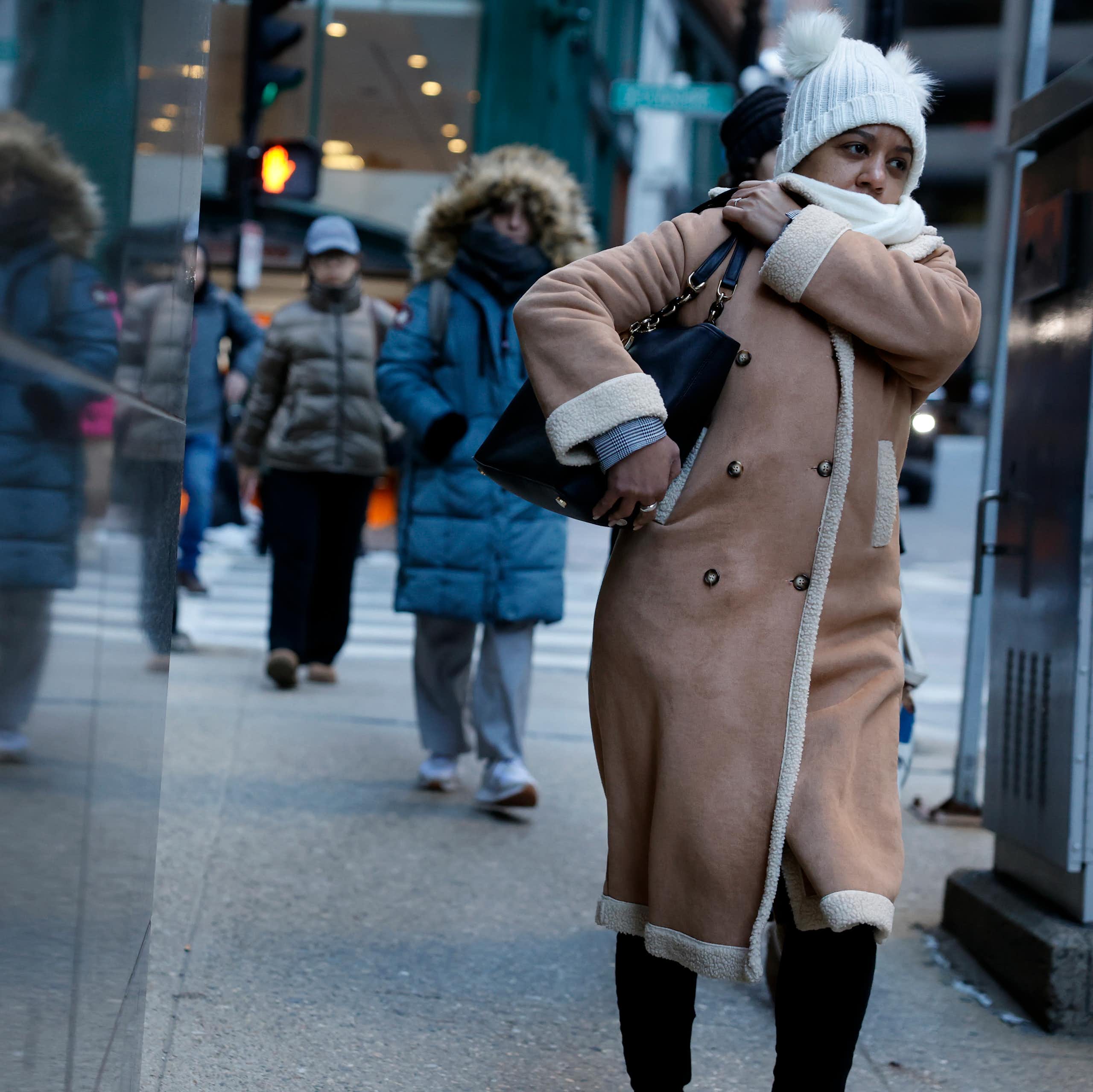 As pessoas se aglomeram nas ruas de uma cidade, bem agasalhadas contra o frio.