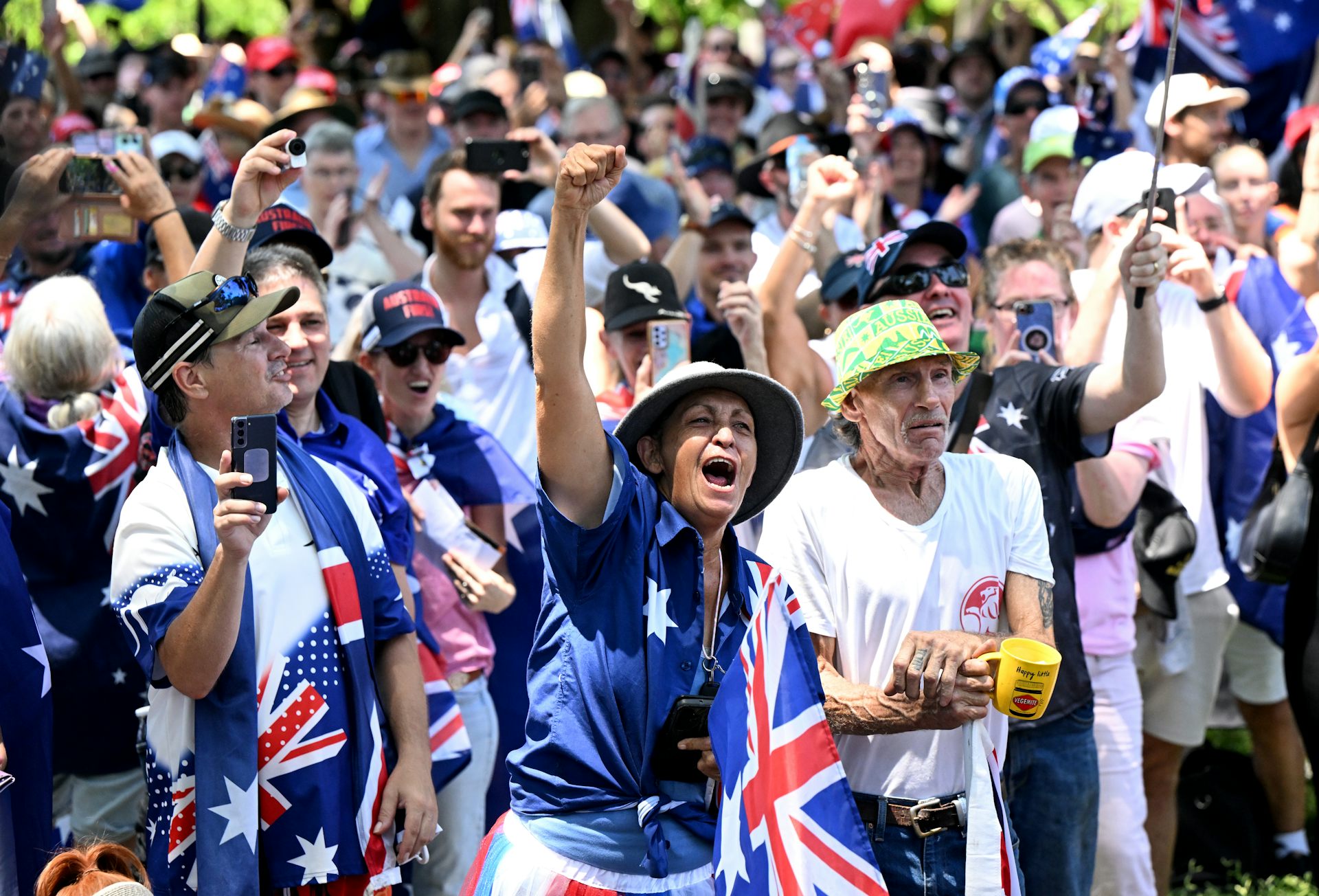 A group of protester chanting covered in Australian flags