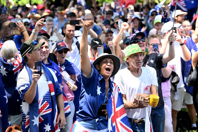 A group of protester chanting covered in Australian flags