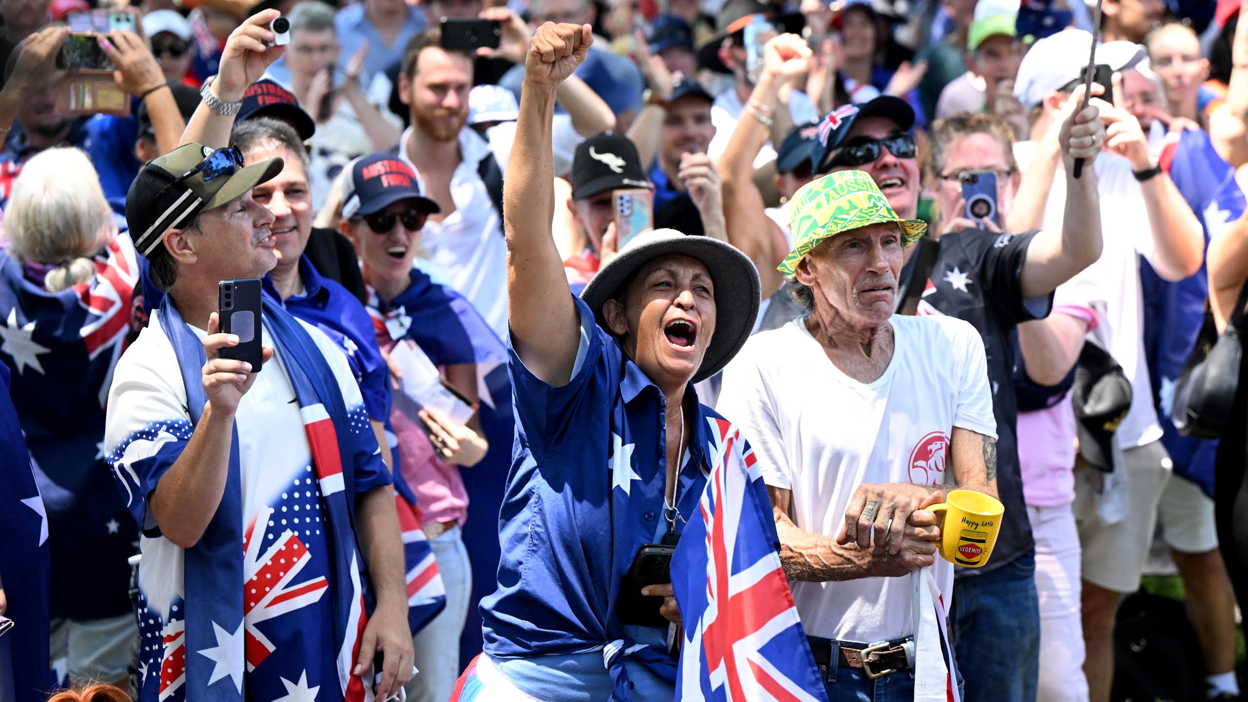 A group of protester chanting covered in Australian flags