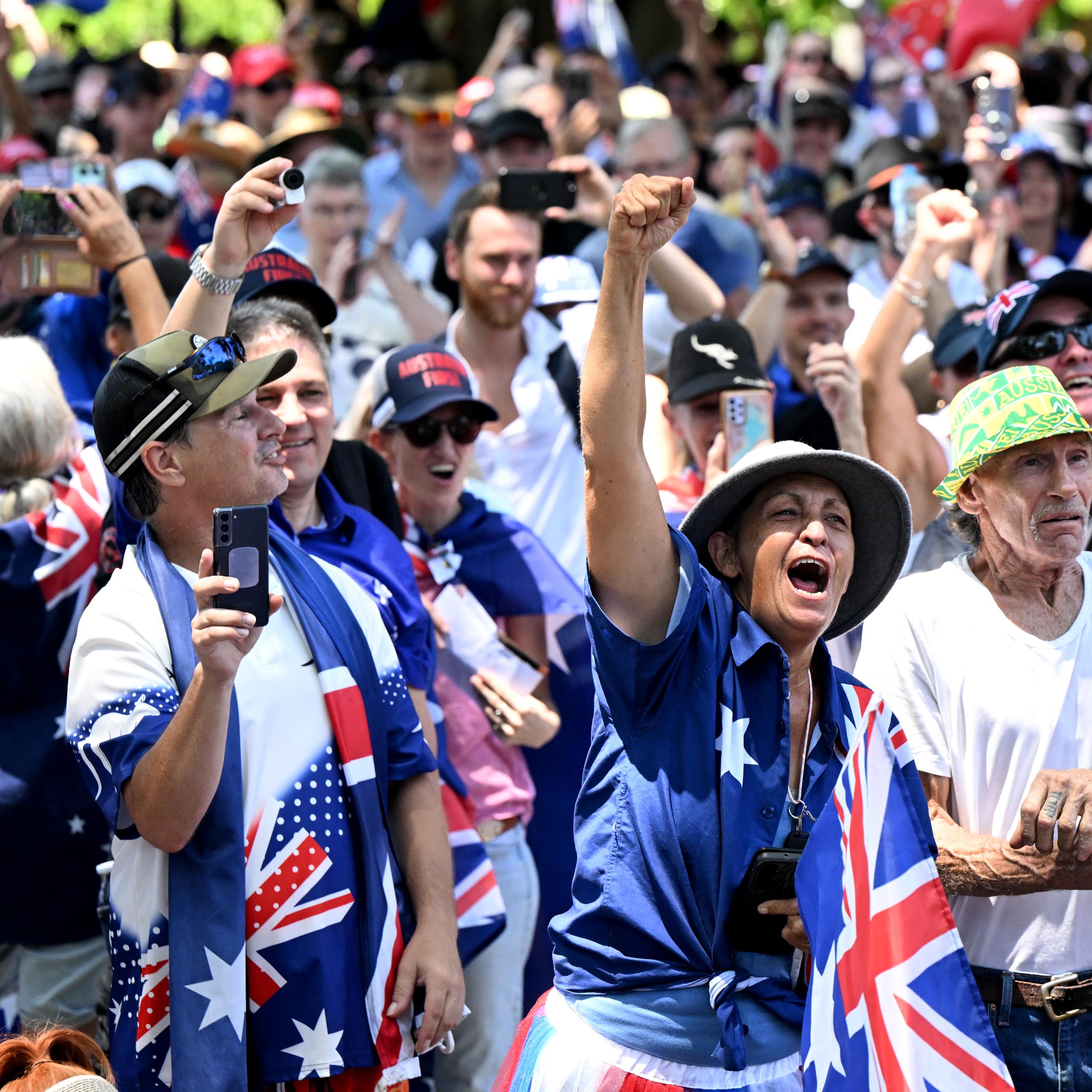 A group of protester chanting covered in Australian flags