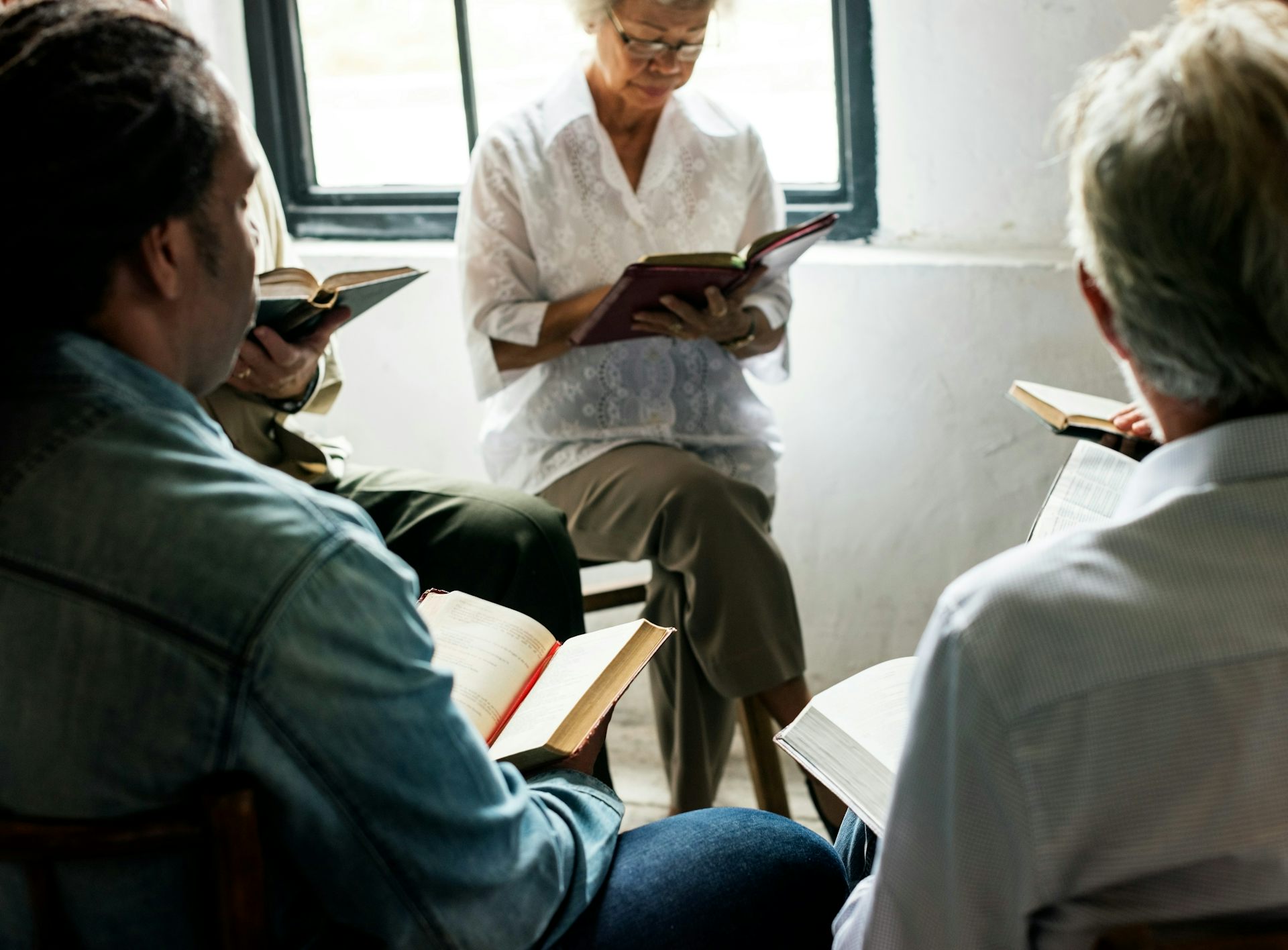 People sitting in a circle have books on their laps