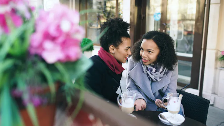 Two young women in winter clothing at a cafe