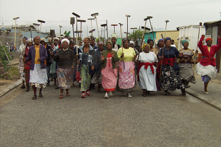 Women carrying brooms