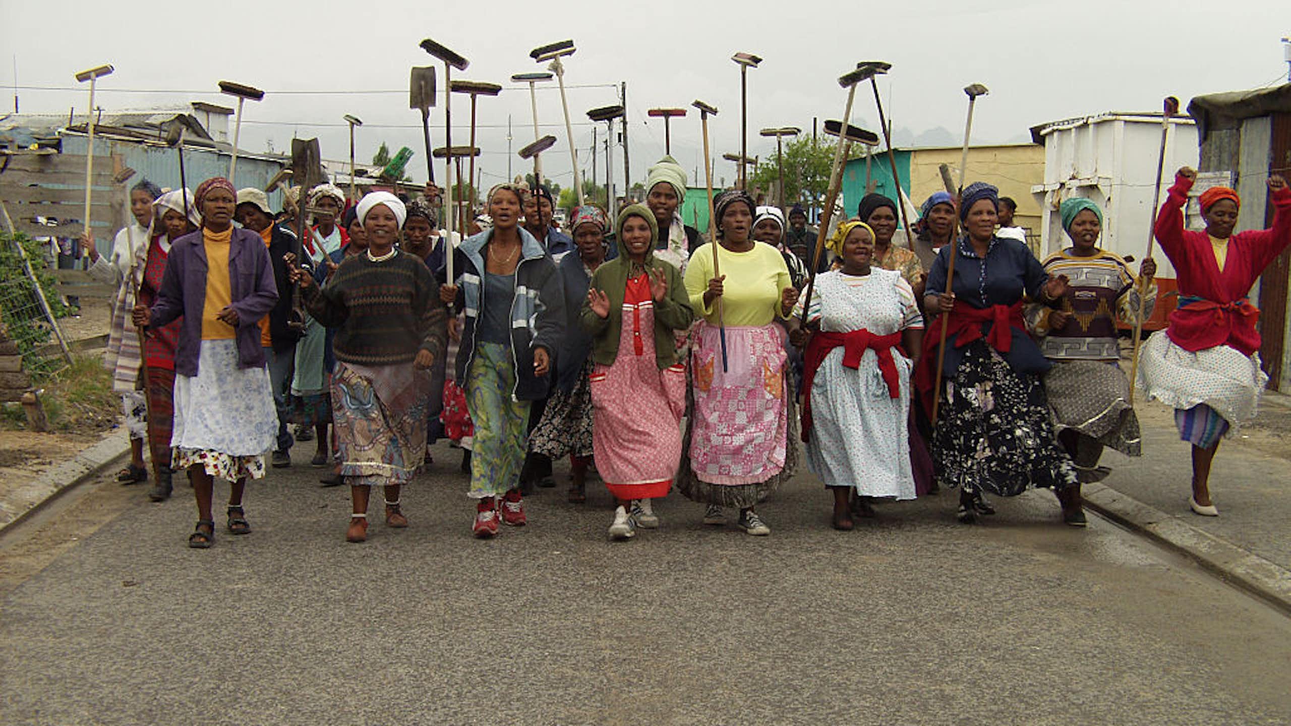 Women carrying brooms