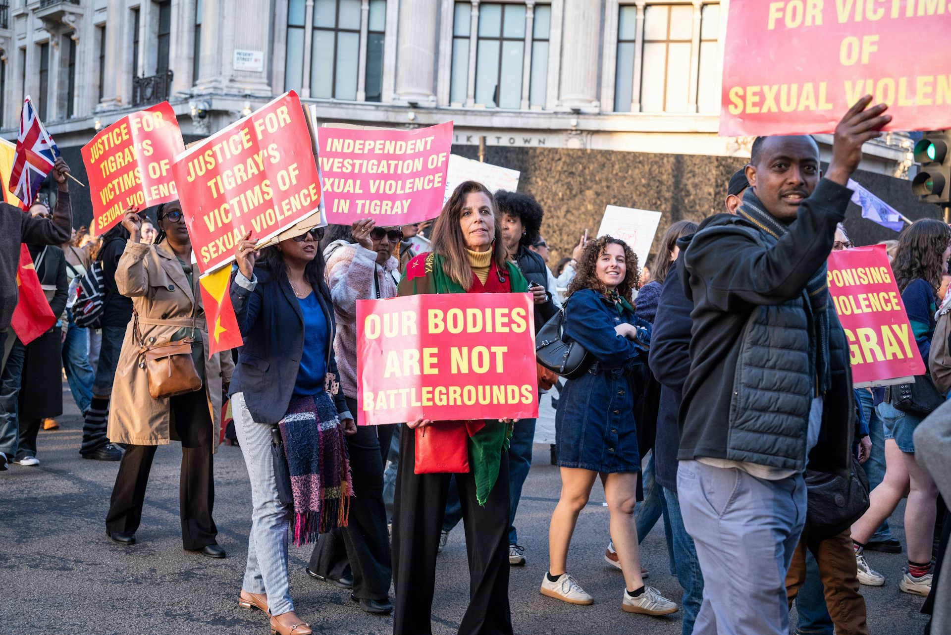Women protest in London, holding banners highlighting the use of sexual and reproductive violence against women in Ethiopia.