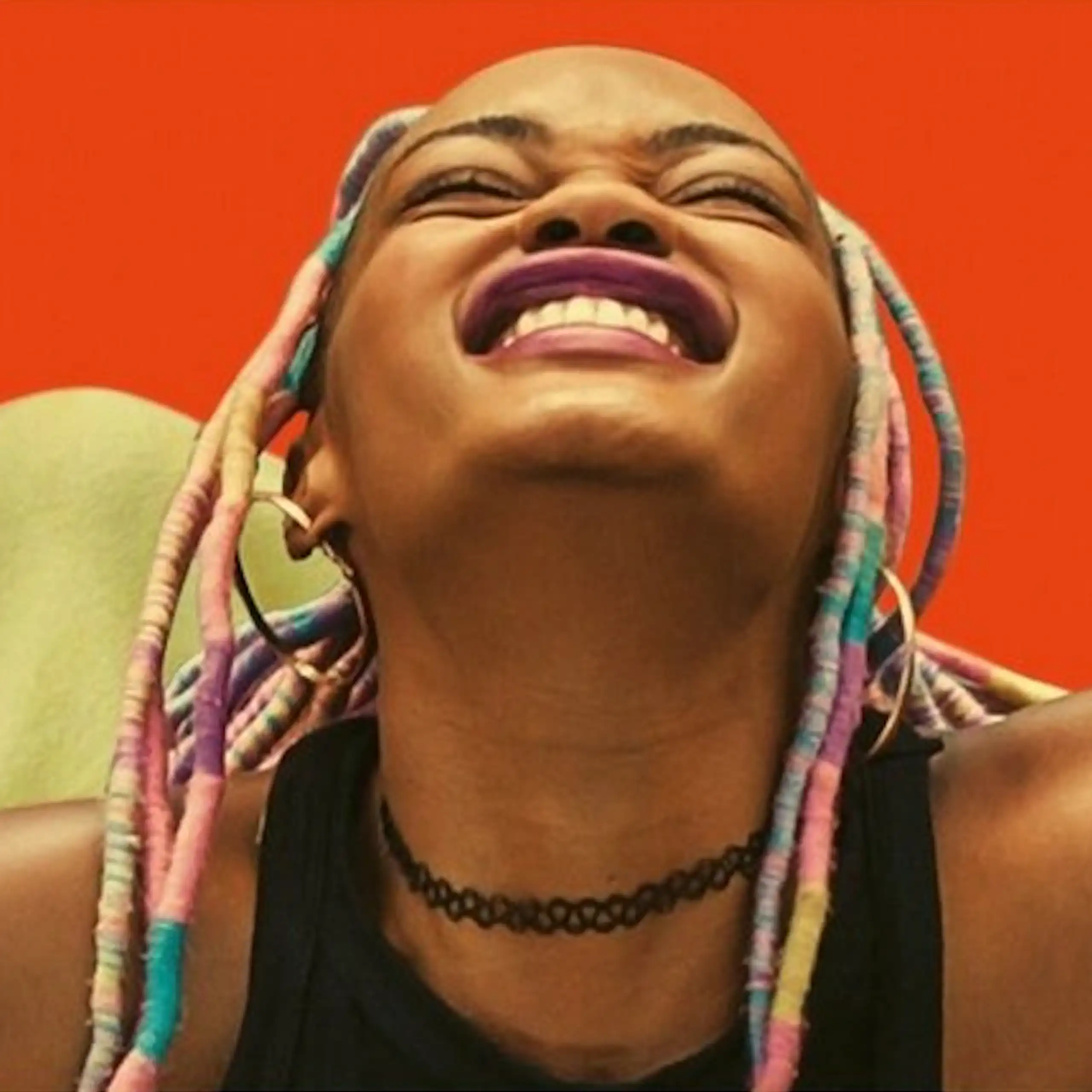 An illustration of a photo with a bright red background, showing two young women smiling broadly.