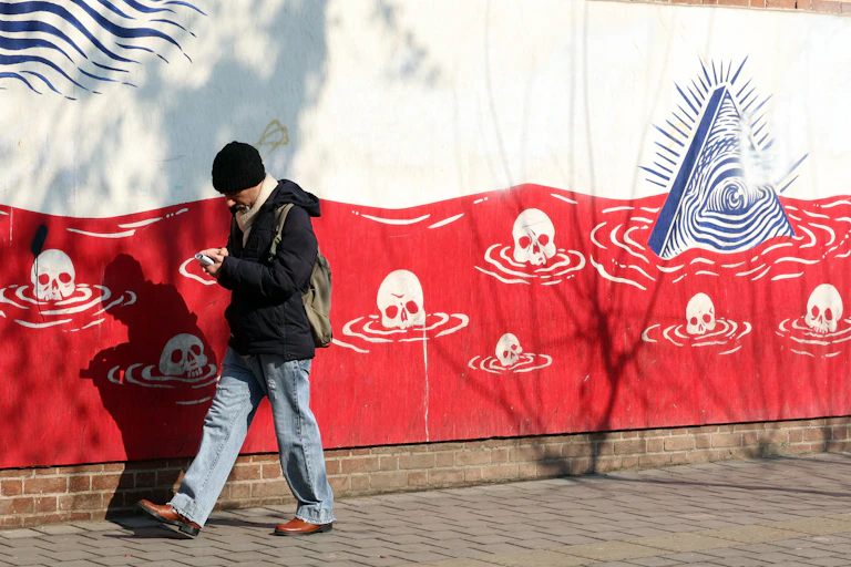 A man walks past an anti-US mural in Iran