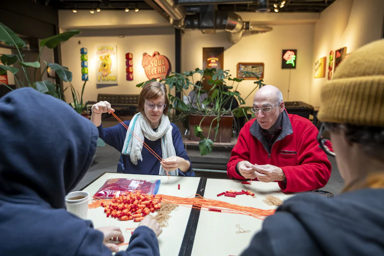 People at a table with a pile of whistles and cords in the middle.