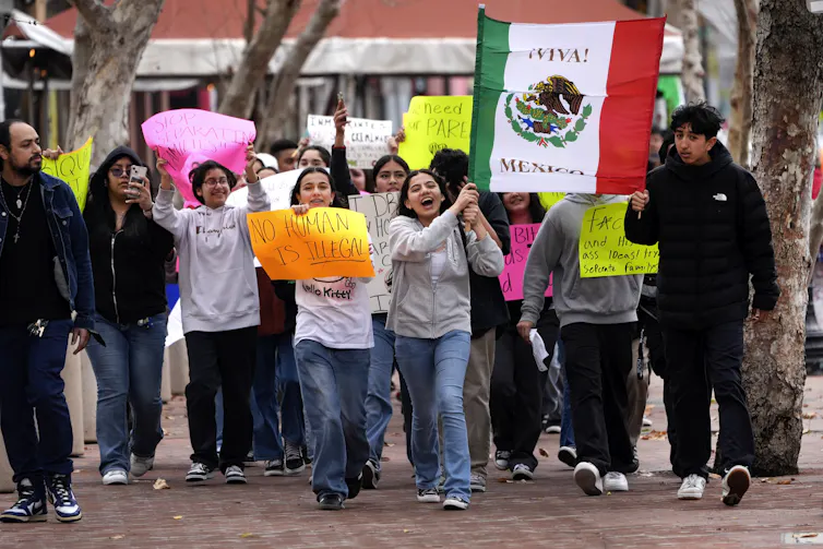 People seen rallying outside, some with signs that say no human is illegal.