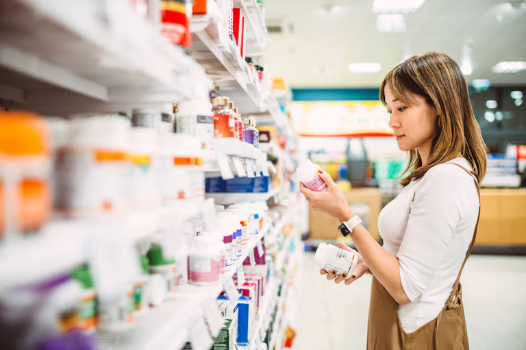 Young woman browses the shelf of a pharmacy.