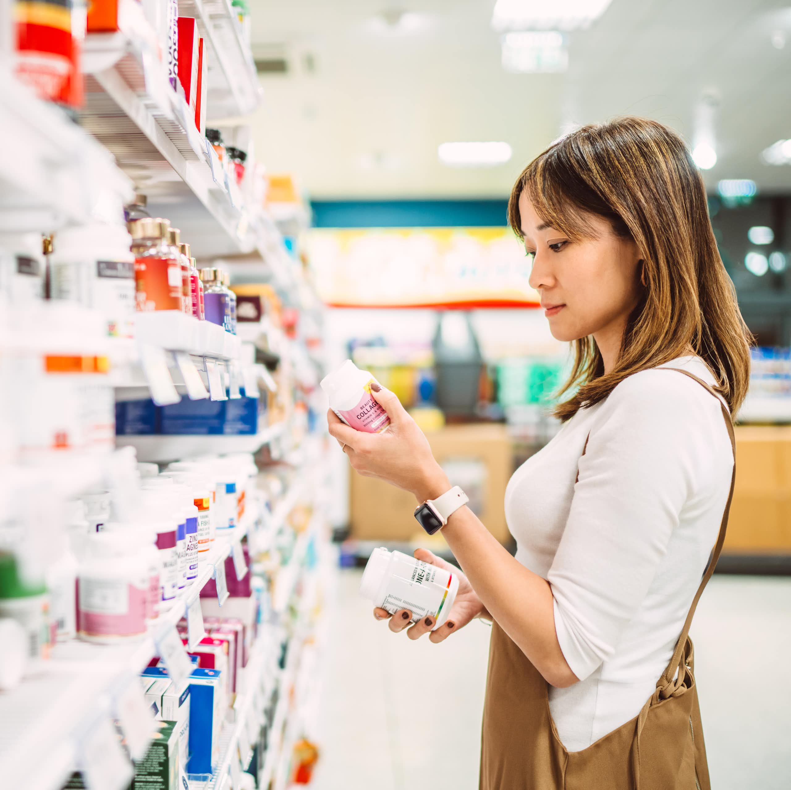 Young woman browses the shelf of a pharmacy.
