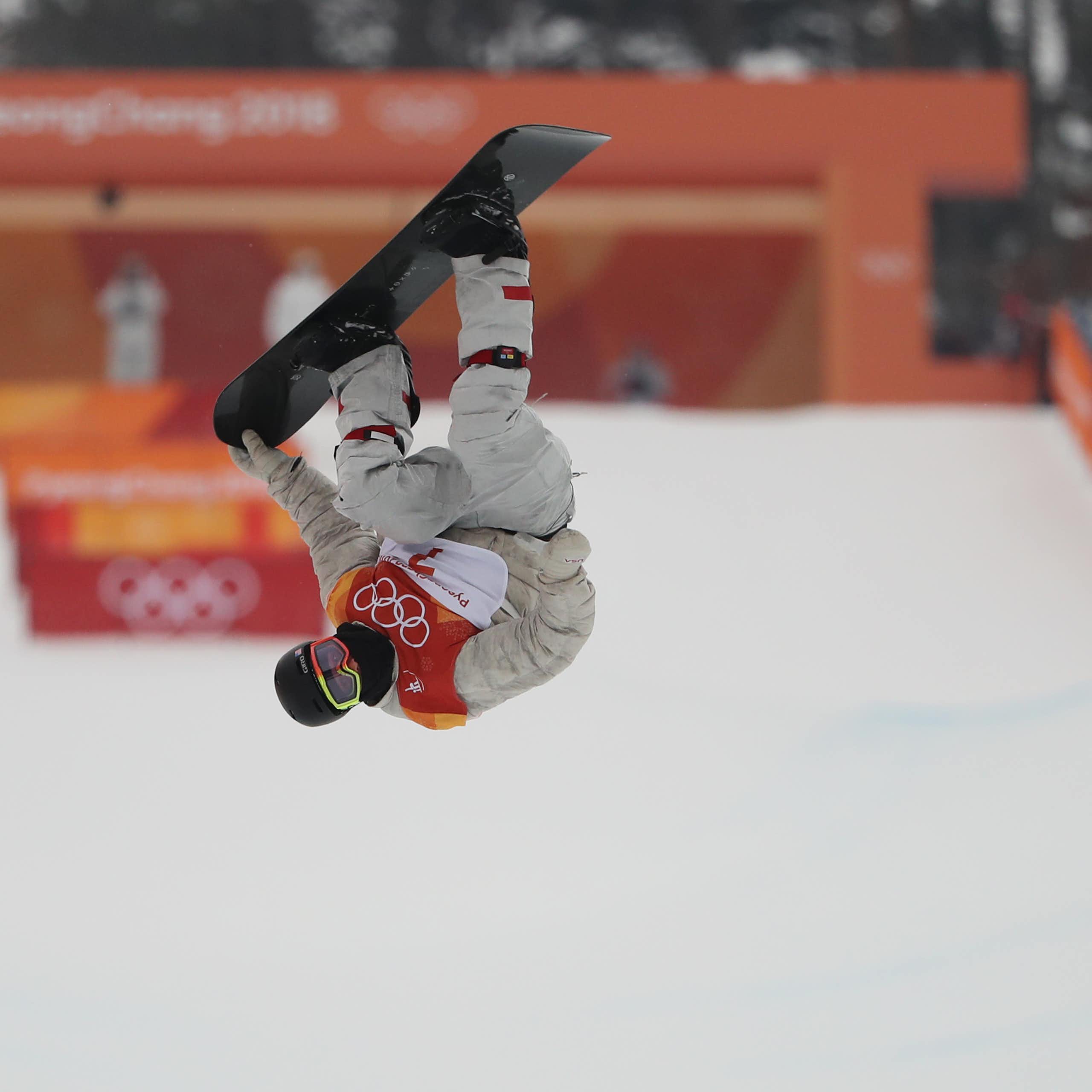 Un snowboarder fait une figure