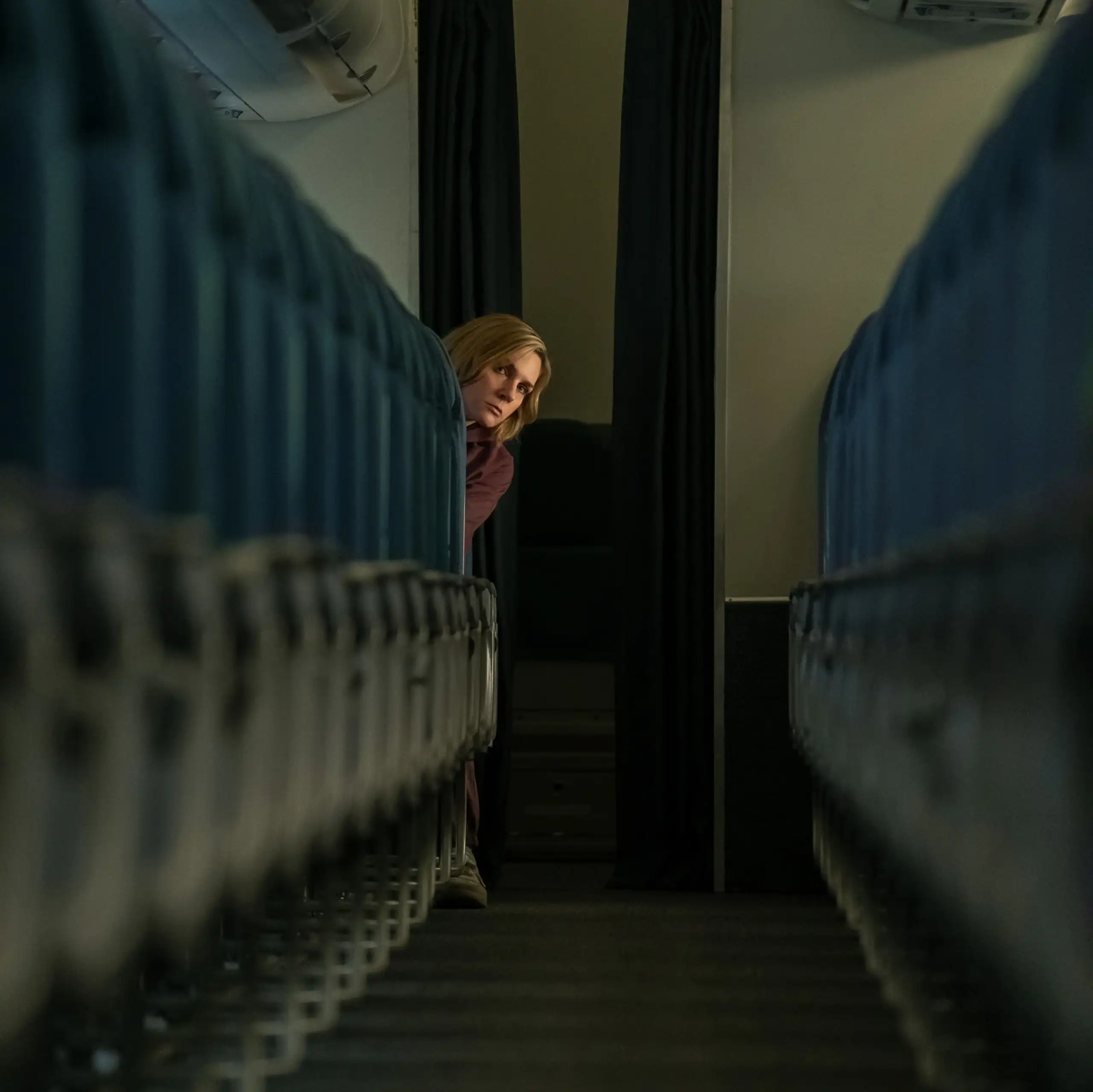 Una mujer se sienta sola en un avión vacío.