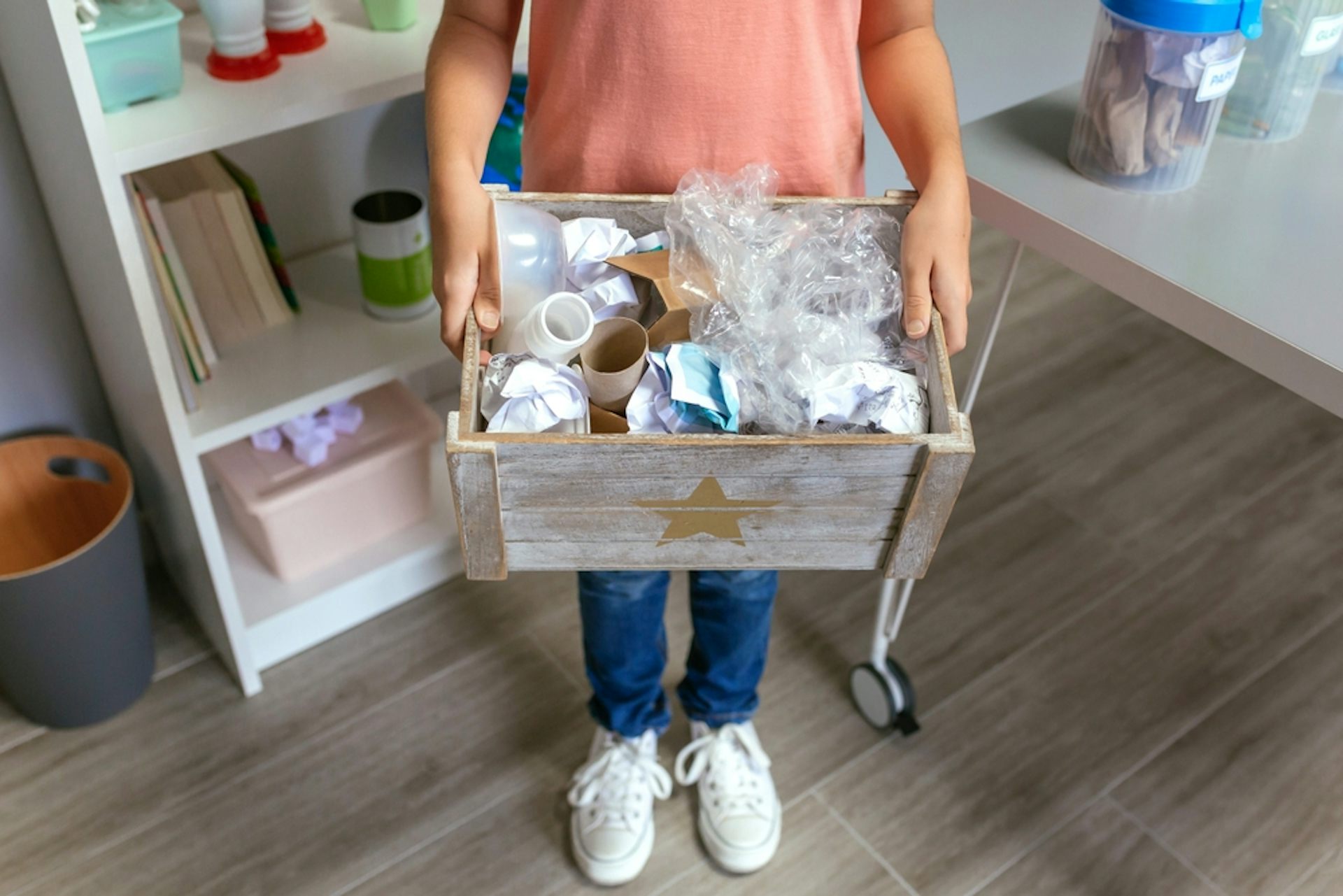 Un enfant avec une caisse de déchets.
