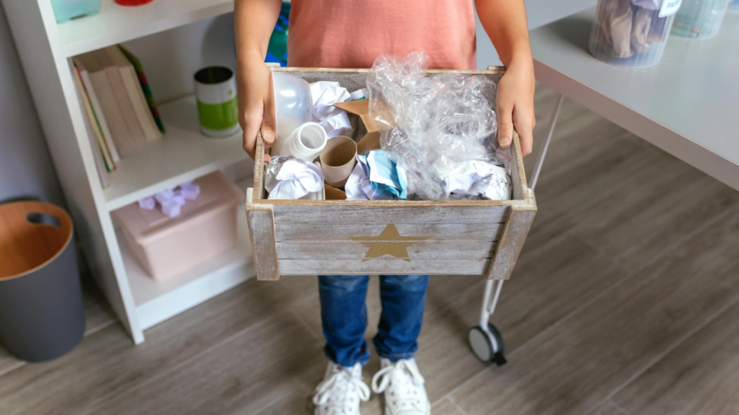 Un enfant avec une caisse de déchets.