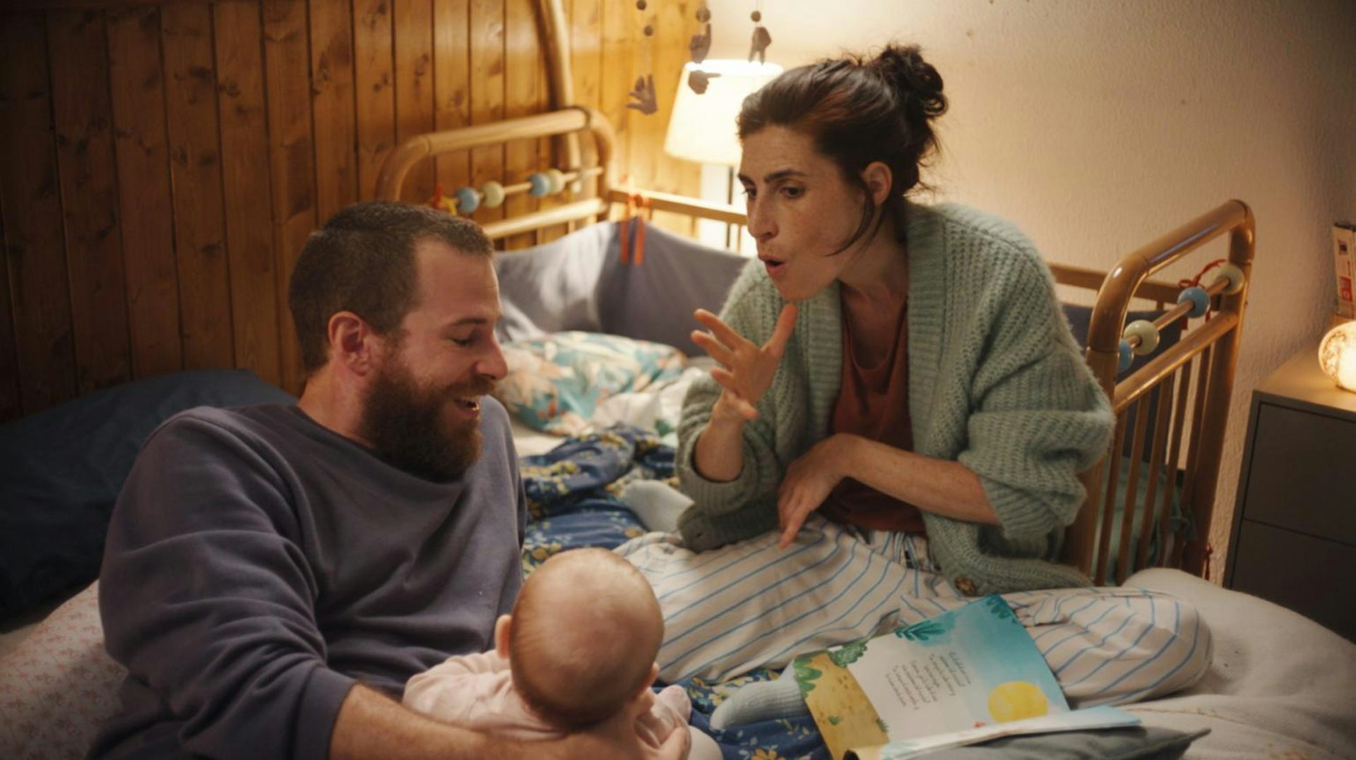 Una mujer que habla el lenguaje de signos junto a un hombre y un bebé.