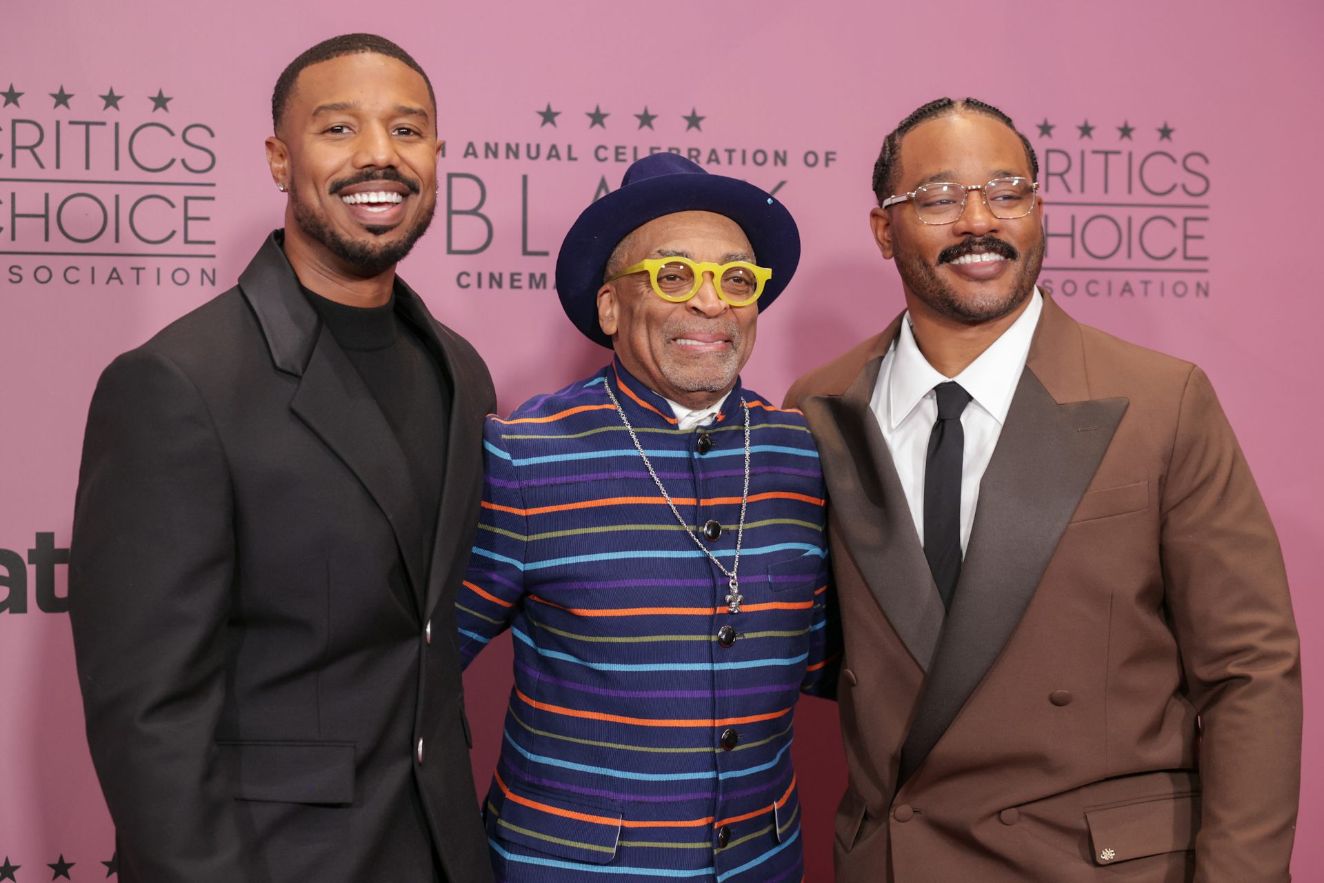 Tres hombres negros posan delante de un fondo de 