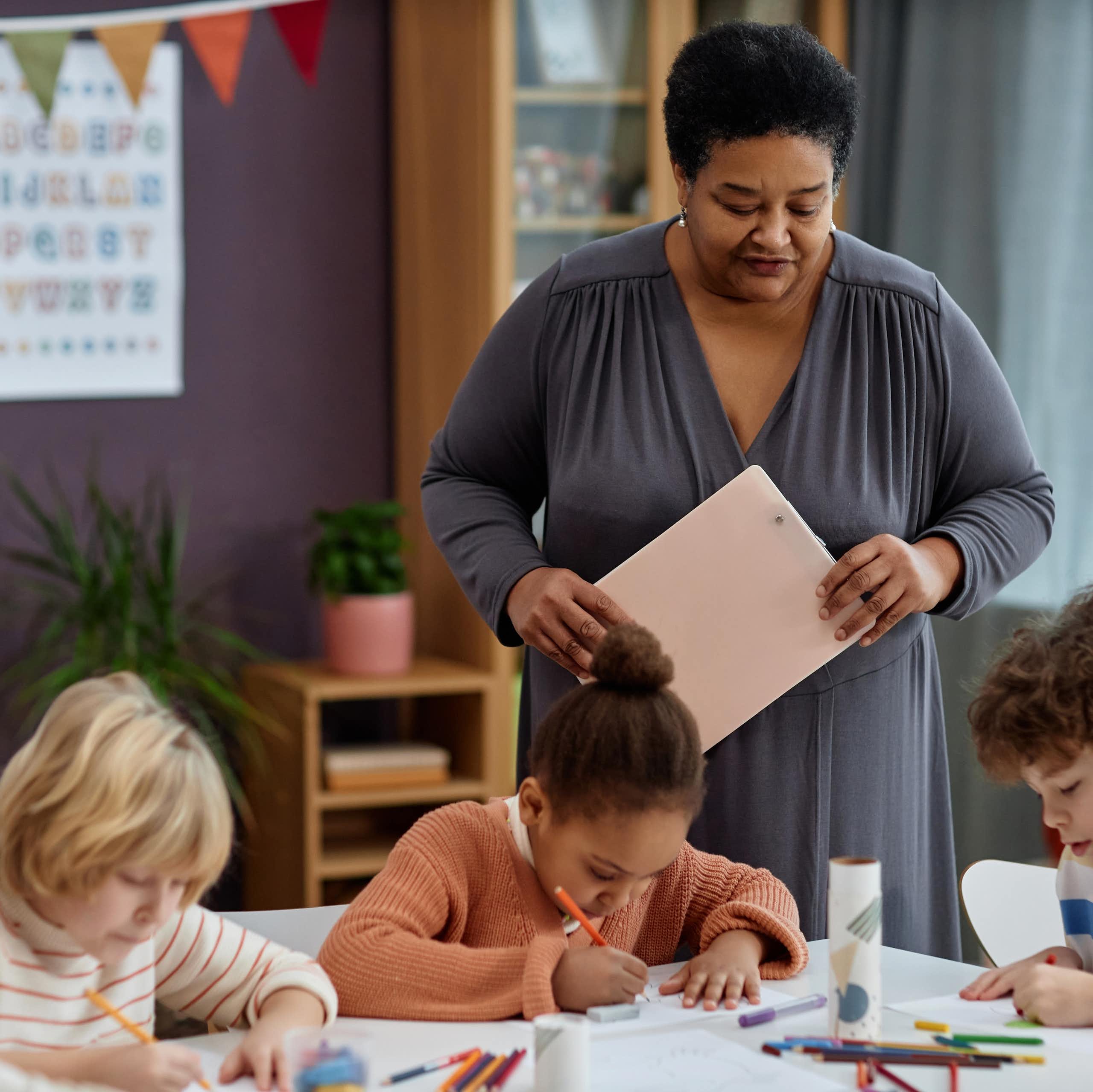 Una profesora observa lo que hacen los niños.