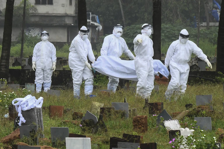 People in protective suits prepare to cremate the body of a 12-year-old boy died of the Nipah virus in Kozhikode, Kerala state, India, Sunday, Sept.5, 2021