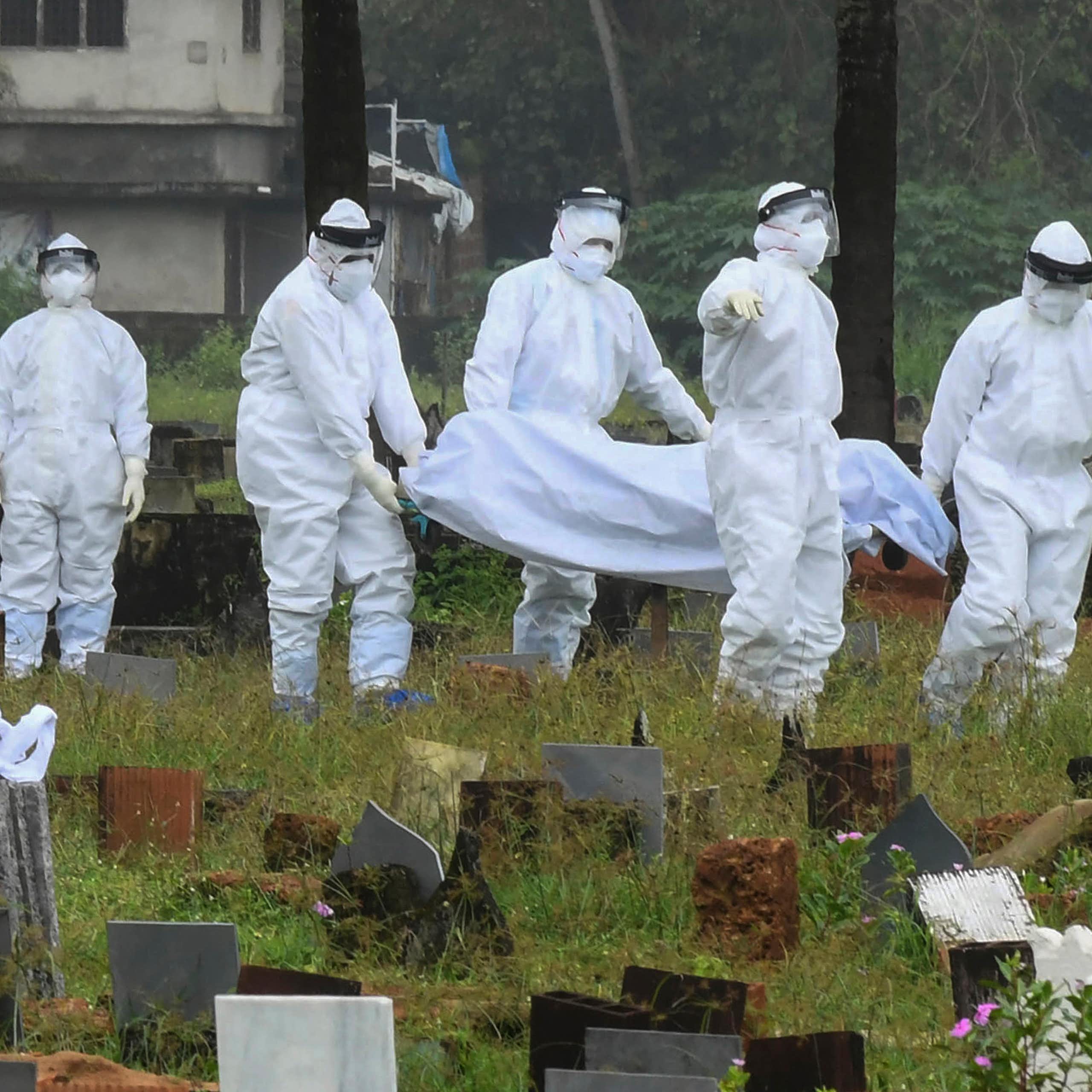 People in protective suits prepare to cremate the body of a 12-year-old boy died of the Nipah virus in Kozhikode, Kerala state, India, Sunday, Sept.5, 2021