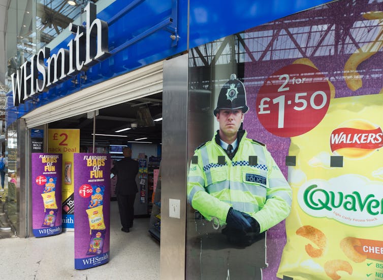 A cardboard cut-out of a police officer in the window of a WHSmith