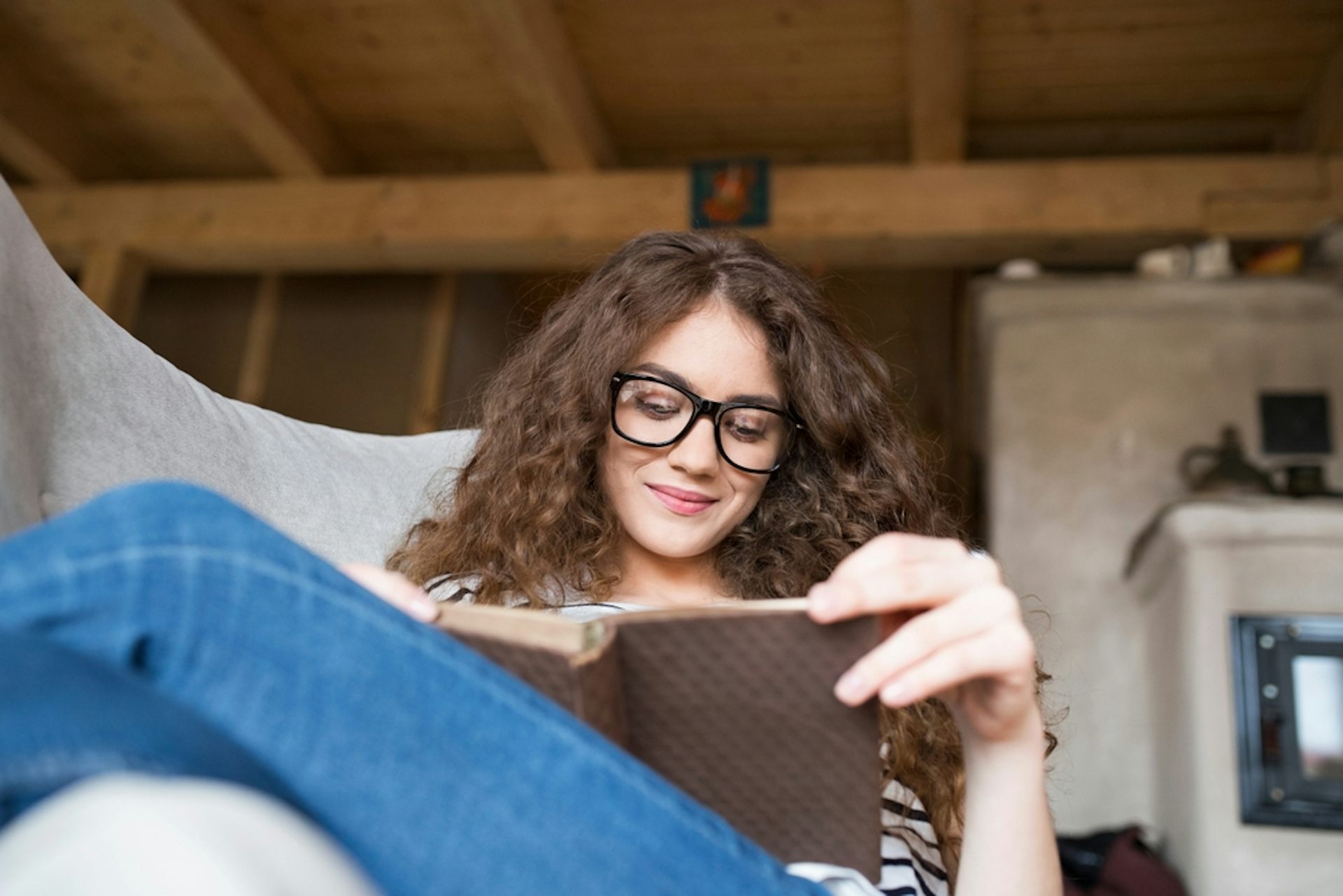 A young woman is reading in her living room