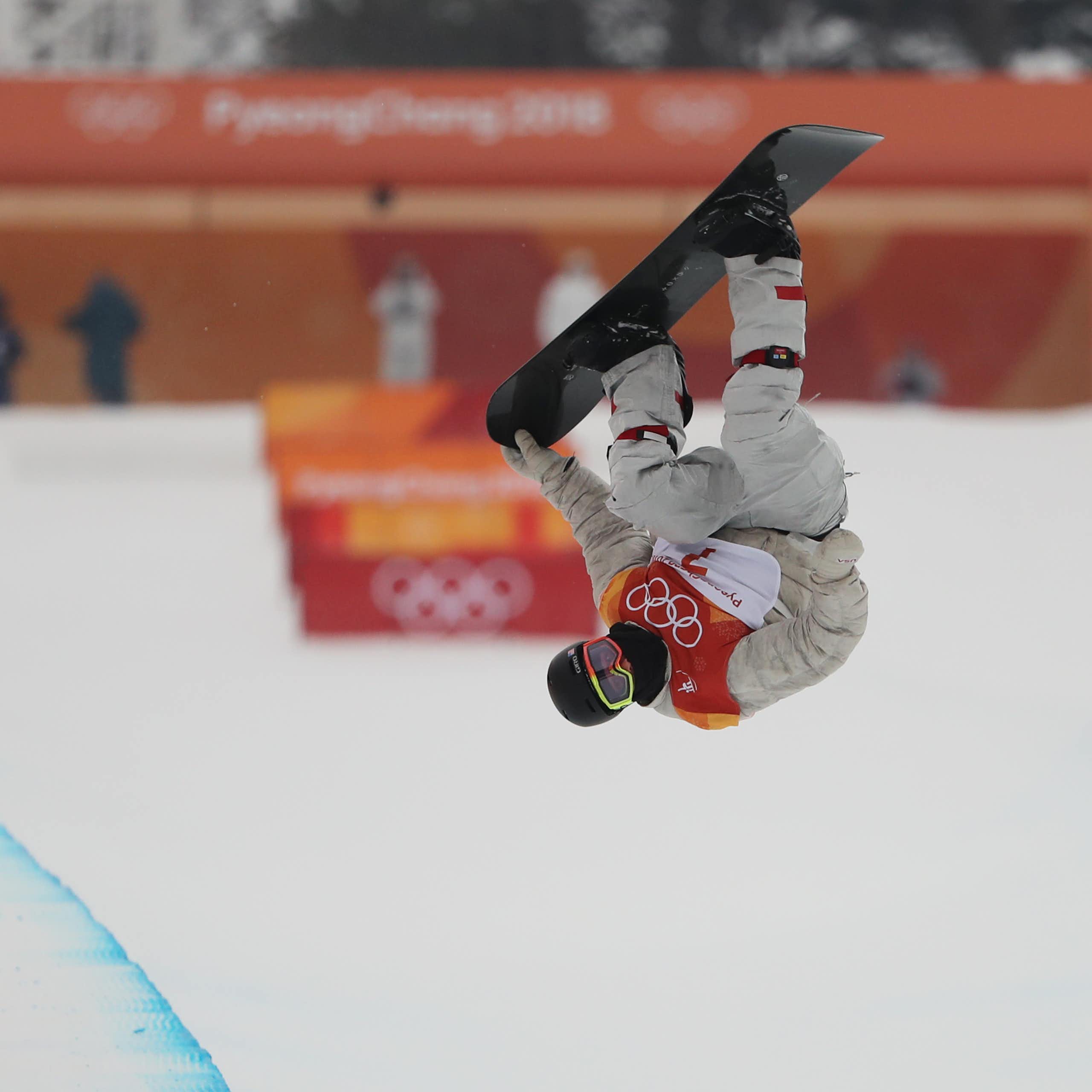 An Olympic snowboard rider performs a rotation.