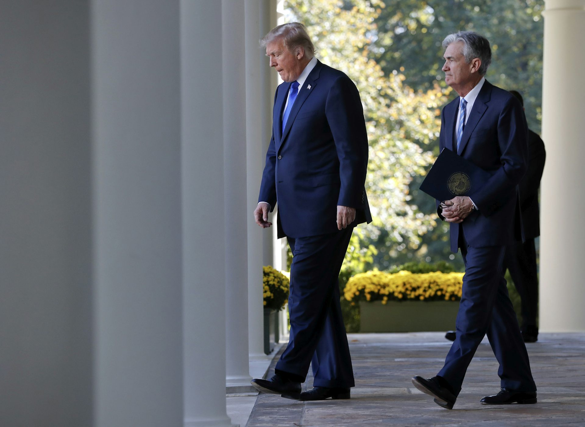 Two men in suits walk outside.