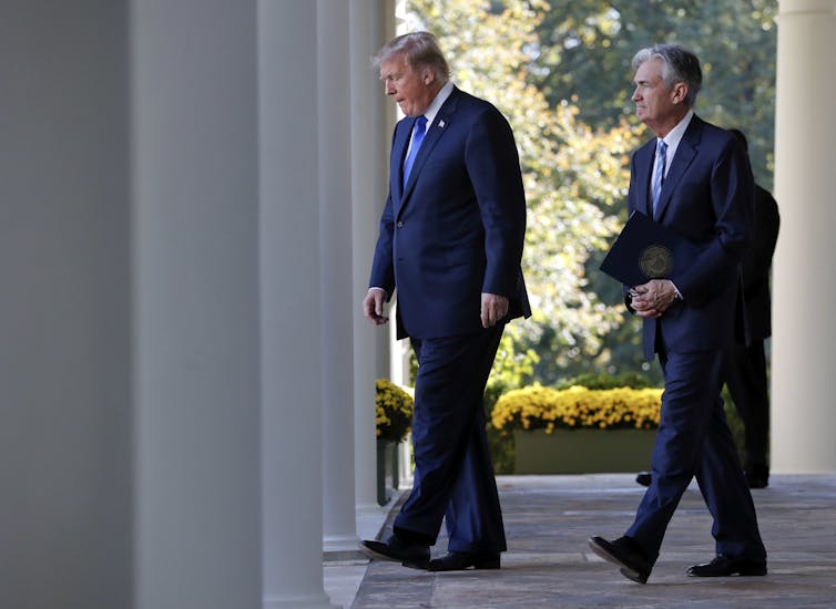 Two men in suits walk outside.