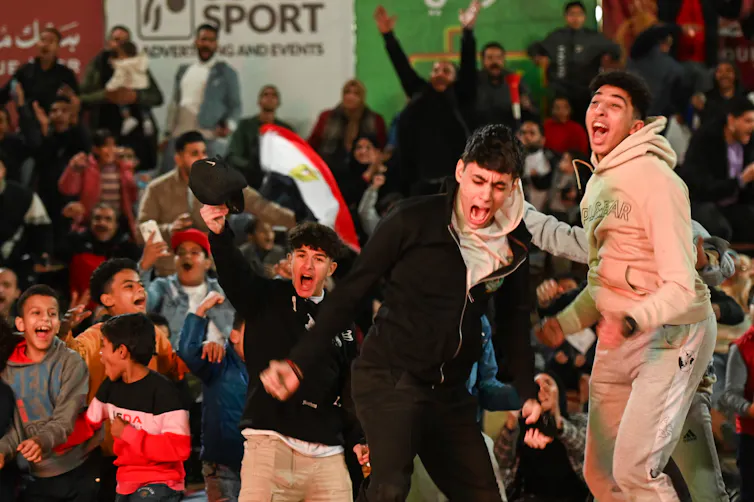 Young boys cheer and shout, their faces lit with excitement.