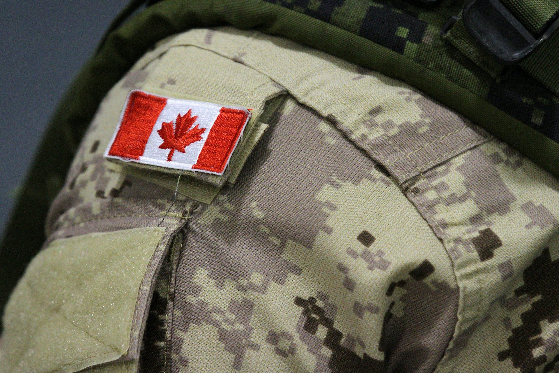 a small canadian flag on the shoulder of a soldier's uniform